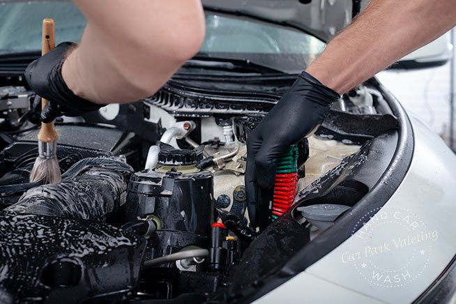 worker-carefully-cleaning-engine-bay-with-brush