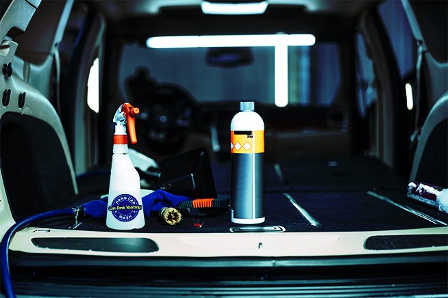 image of cleaning supplies in the trunk of an open car with car wash watford logo